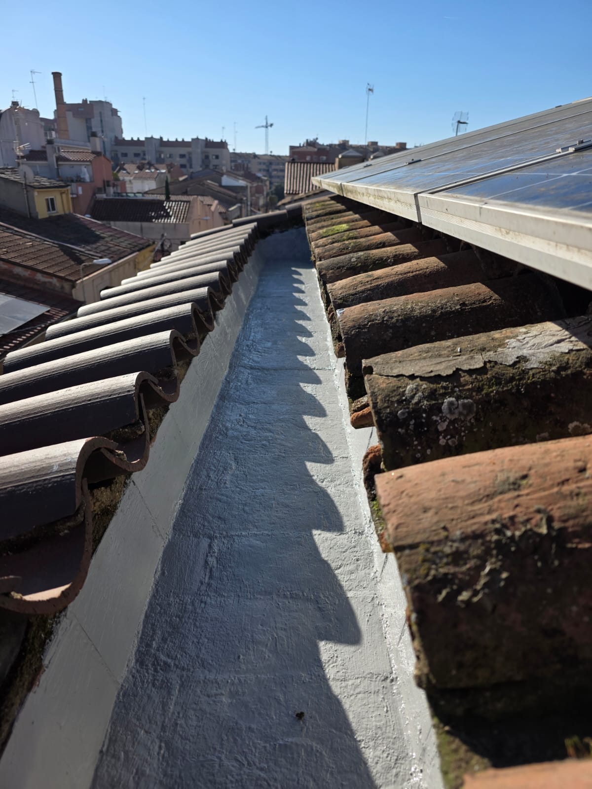Tejado con tejas, vista del canal central y paisaje urbano al fondo.