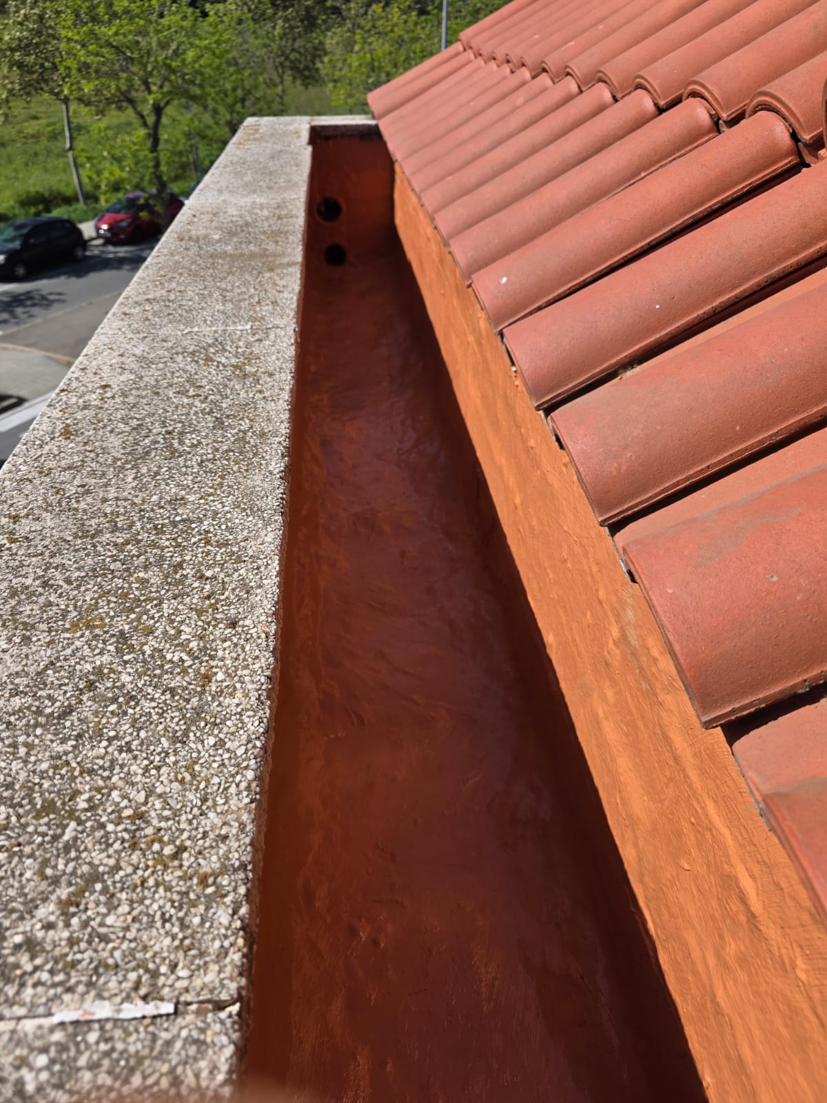 Canalón elevado con una superficie de azulejos rojos y borde de hormigón.
