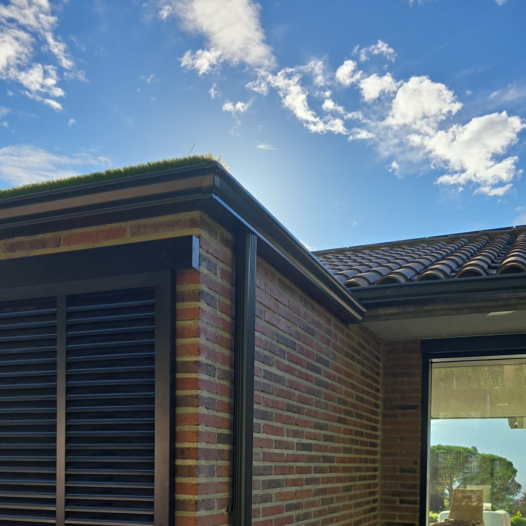 Canalón de desagüe en la parte superior de una construcción, con uniones visibles.