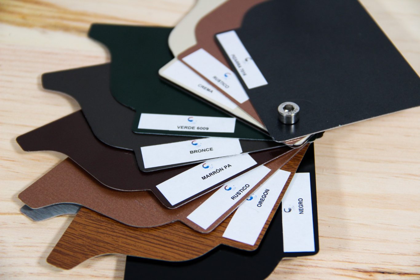 Muestras de colores y texturas de materiales en una mesa, sujetas por un anillo.