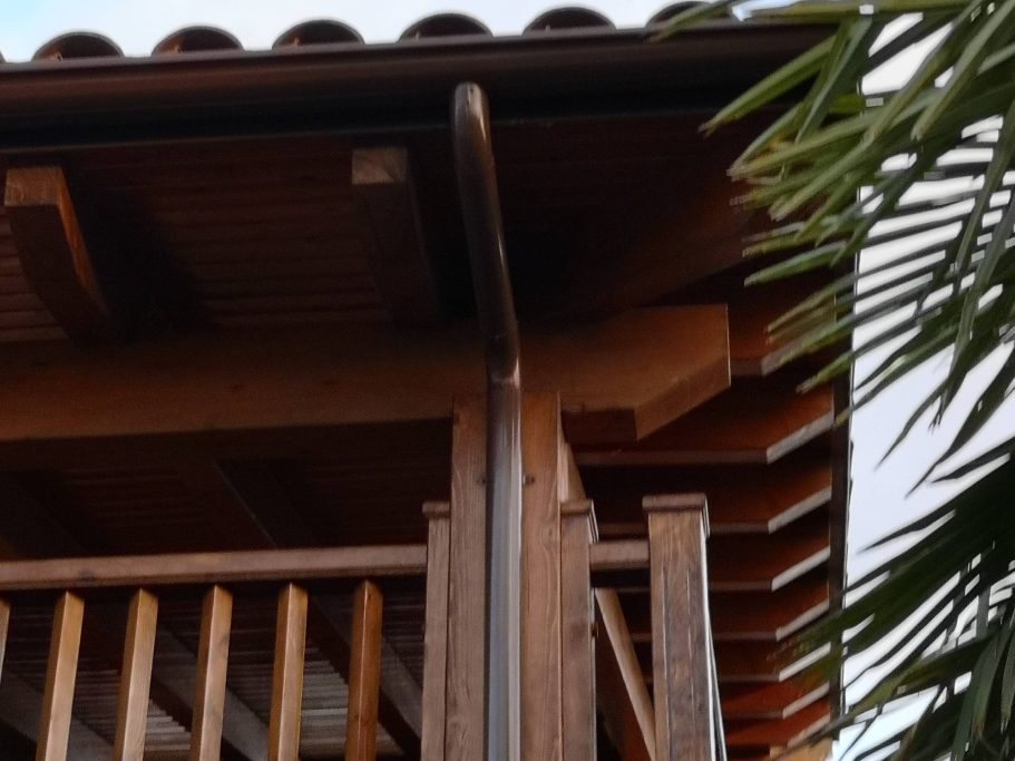 Esquina de un balcón de madera con detalles del diseño arquitectónico.